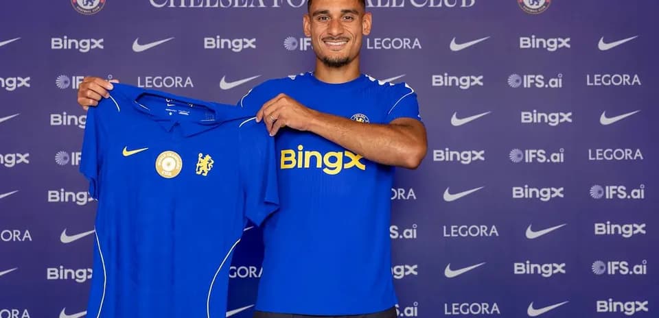 Player holding Chelsea jersey at press event