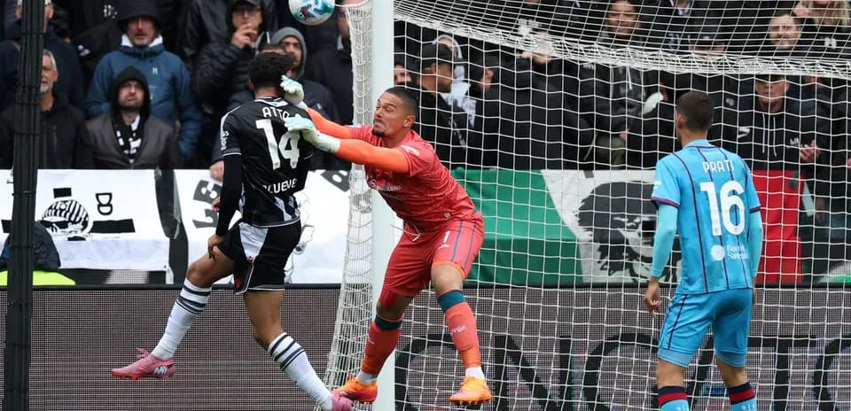 Goalkeeper and defender contesting for the ball