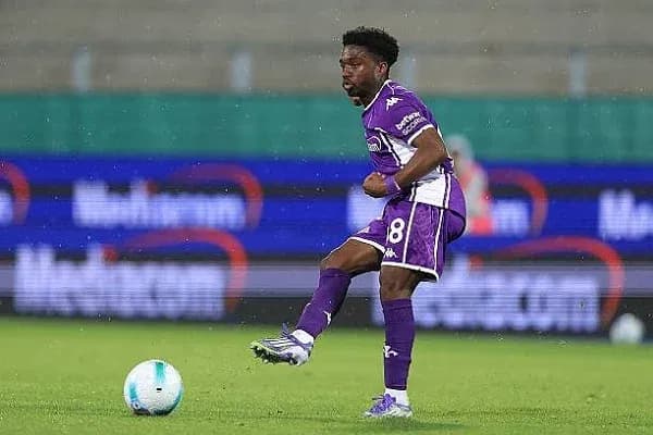 Player in purple kit controlling the ball during match