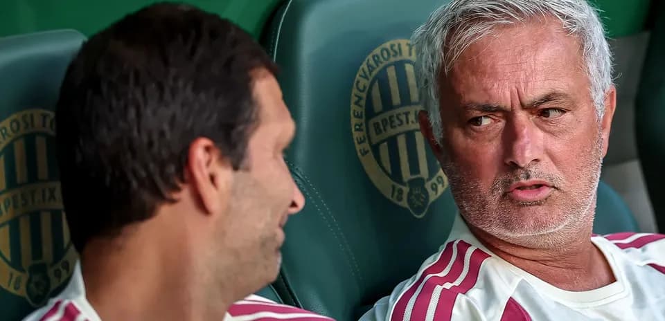 Two coaches seated on the bench during a match