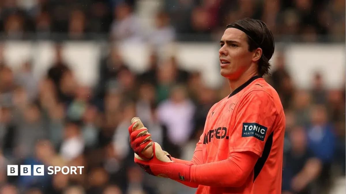 Goalkeeper in orange kit during match action