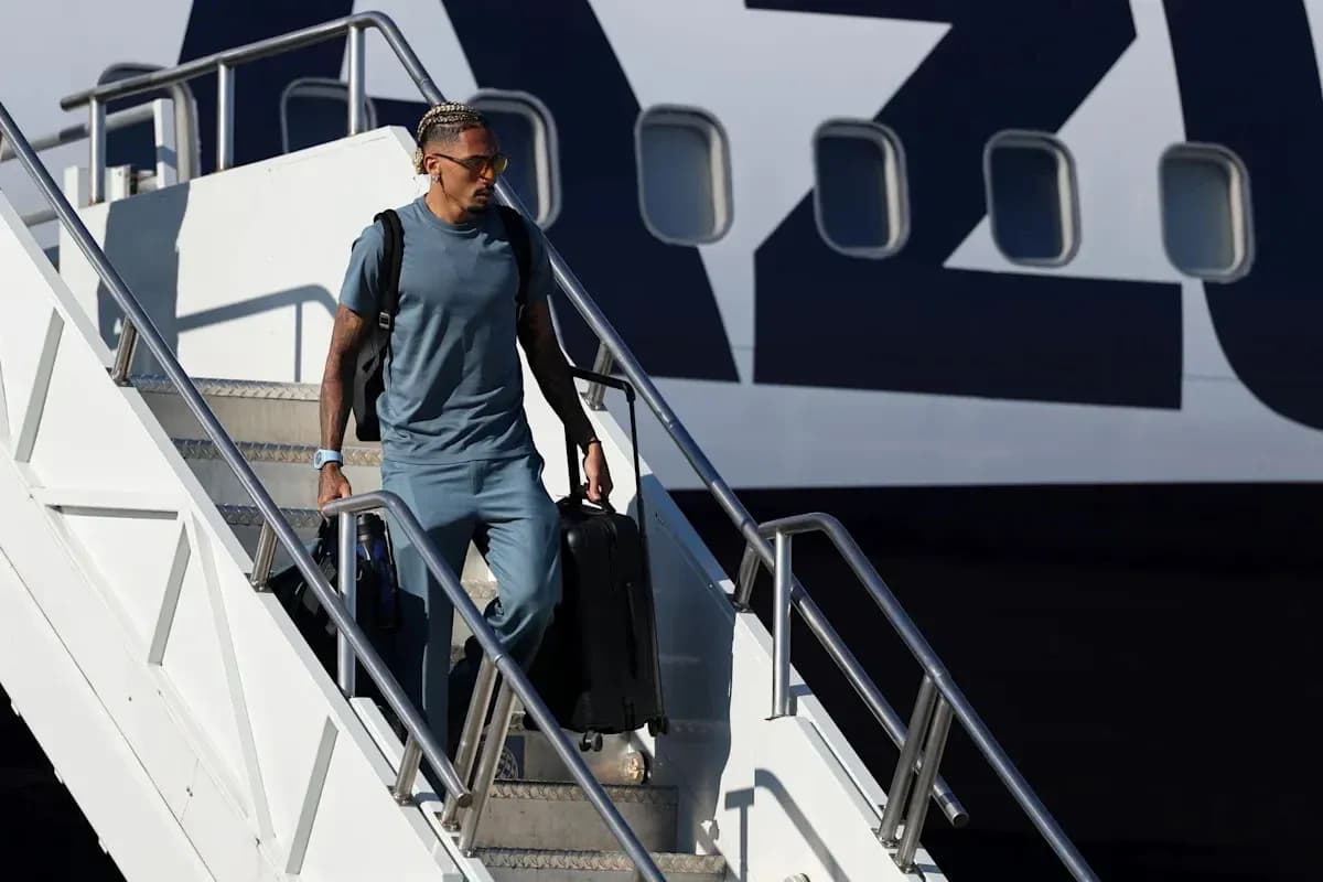 Player exiting airplane with luggage at airport