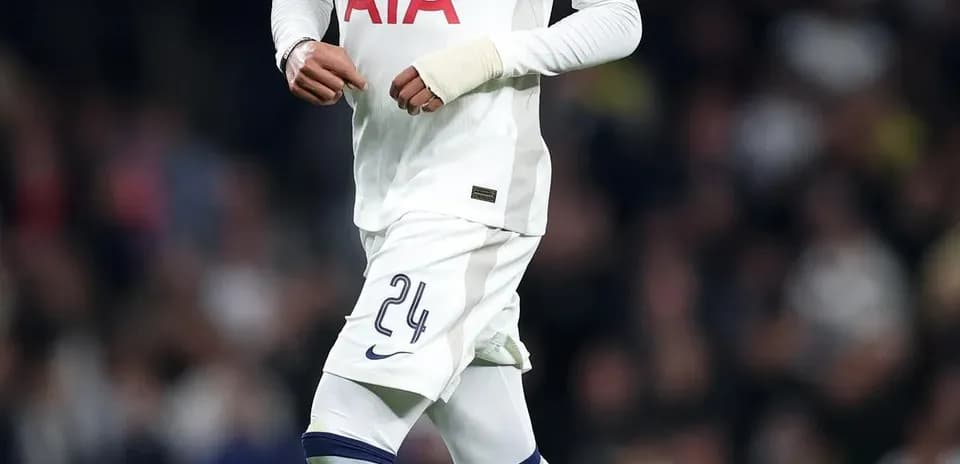 Player wearing Tottenham kit dribbling soccer ball