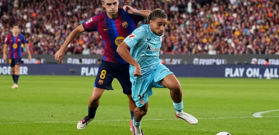 Barcelona player challenging opponent for the ball