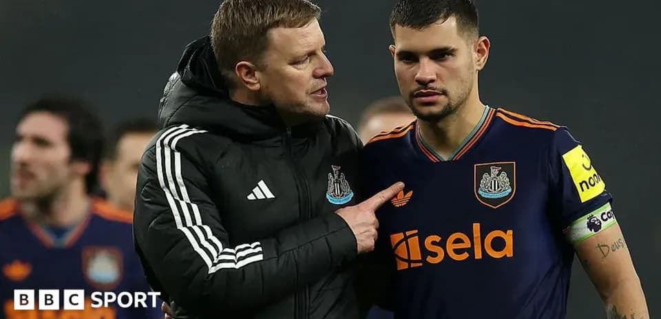 Newcastle United manager speaking to player on pitch