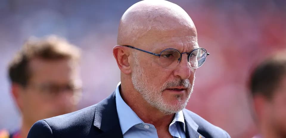 Man in suit and glasses on the sidelines