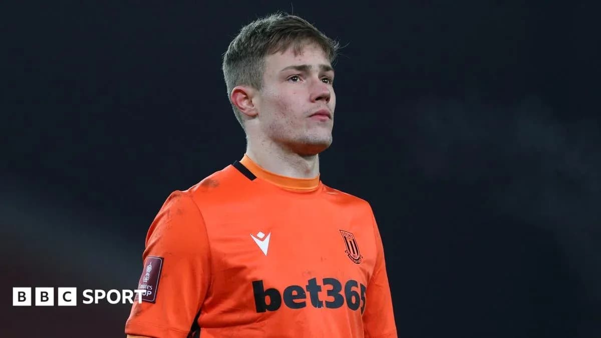 Goalkeeper in orange kit during match preparation