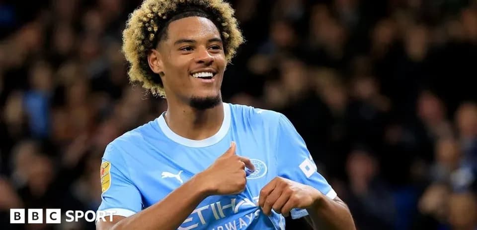 Player celebrating with thumbs up in Manchester City kit