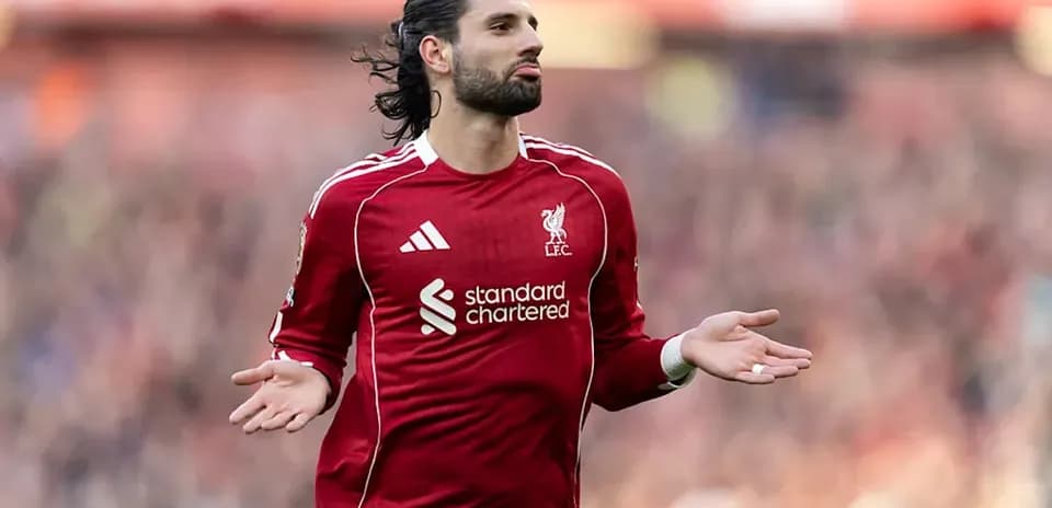 Player gesturing during match in Liverpool kit