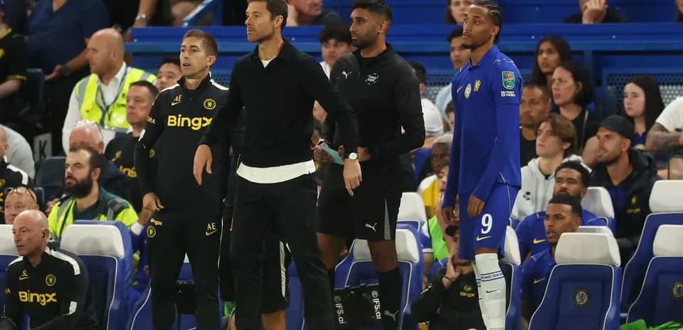 Coaching staff and player on bench during match