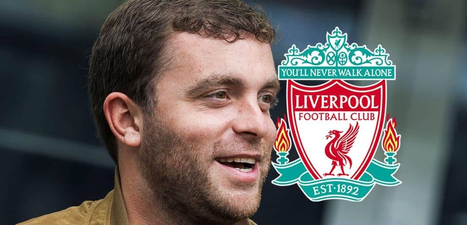 Person smiling next to Liverpool FC club logo