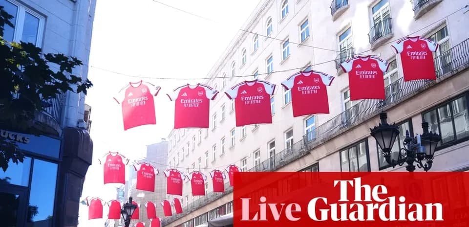 Arsenal jerseys hanging above street in city