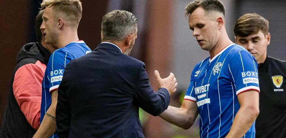 Rangers players interacting with coach during substitution