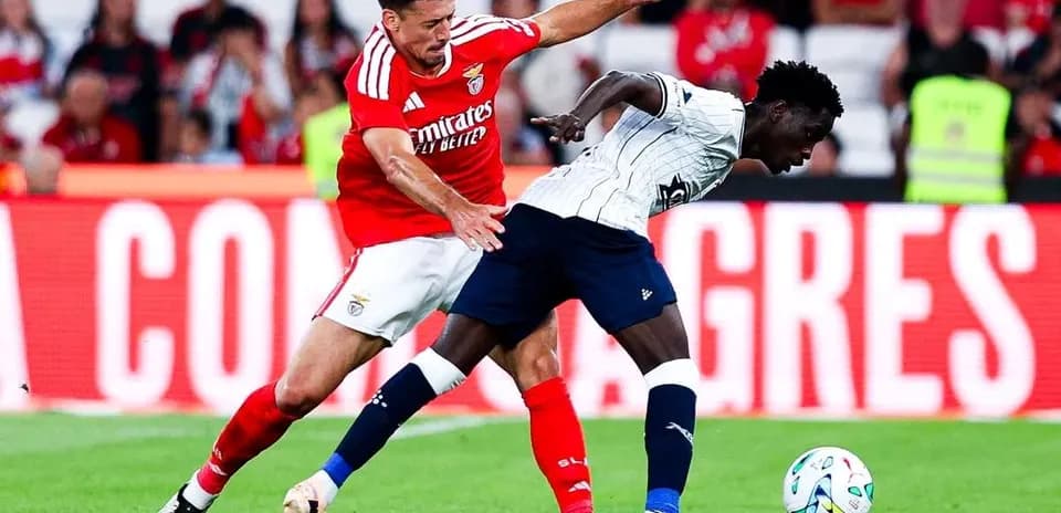 Benfica player tackling Aarhus opponent during match