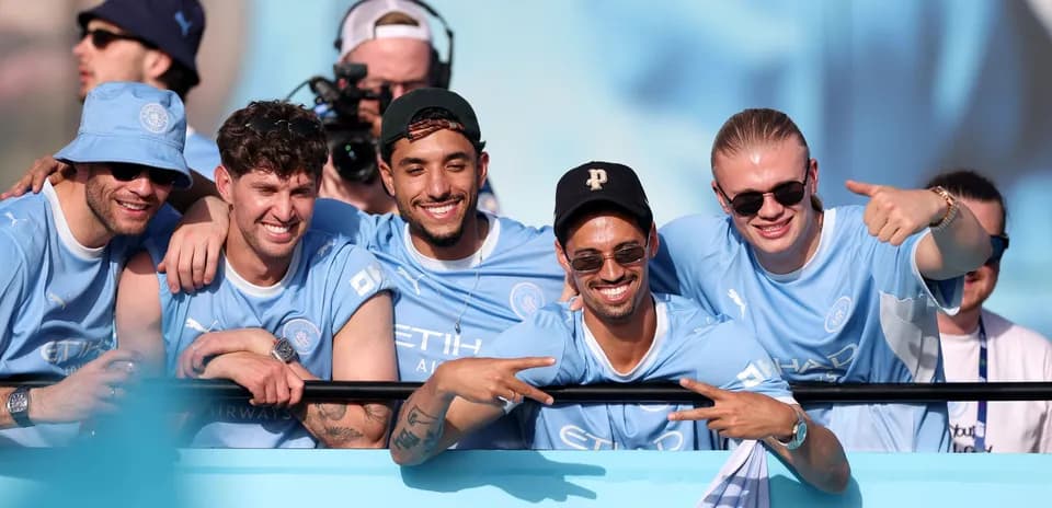 Group of fans celebrating in Manchester City jerseys