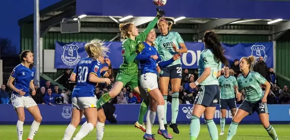 Goalkeeper attempting to catch the ball during match