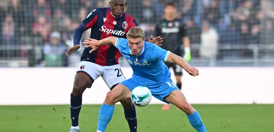 Napoli player challenged by Bologna defender