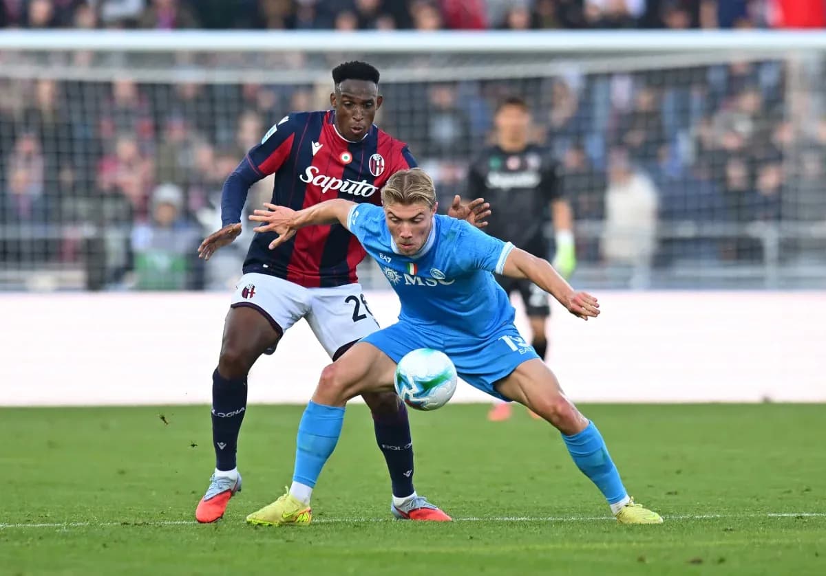 Napoli player challenged by Bologna defender
