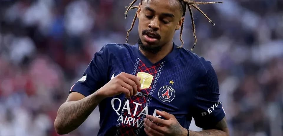 Player examining medal on Paris Saint-Germain jersey