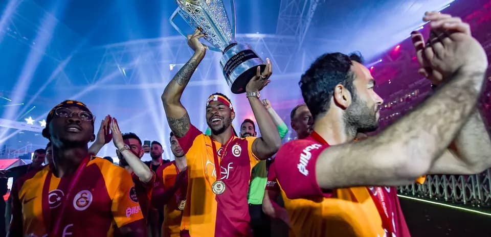 Player celebrating with trophy and teammates after victory