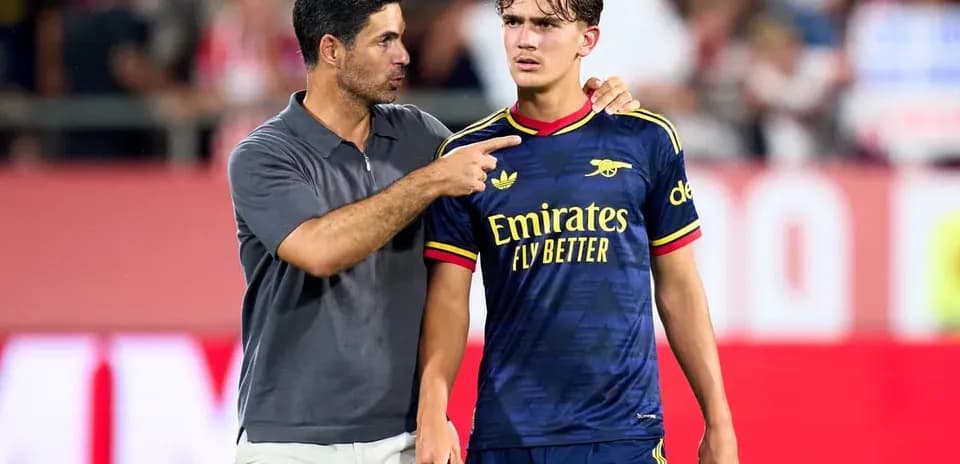 Coach speaking to player on the pitch