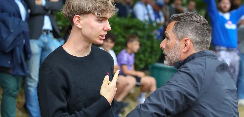 Two men engaged in discussion near spectators