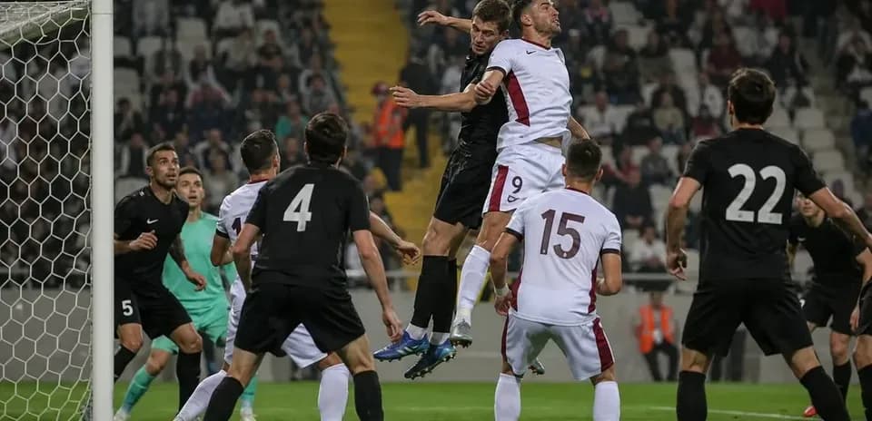 Players contesting a header in a football match