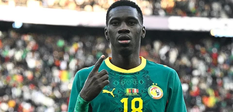 Player in Senegal jersey celebrating with finger raised