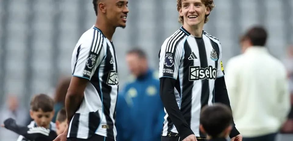 Two Newcastle players talking on the pitch