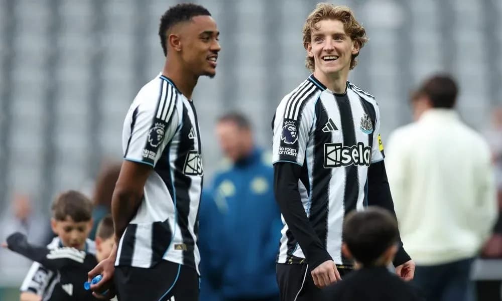 Two Newcastle players talking on the pitch