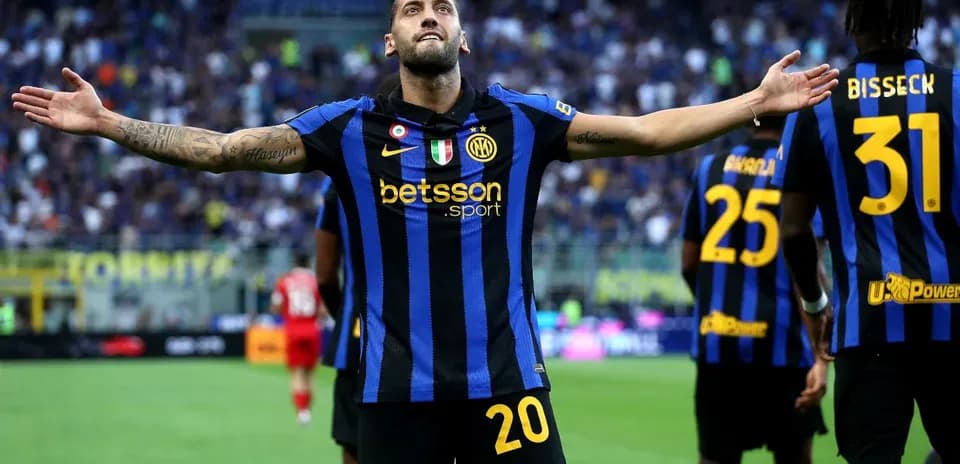 Player celebrating goal with teammates in stadium