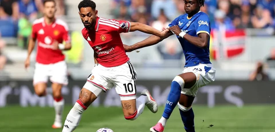 Player in red dribbling past opponent in blue