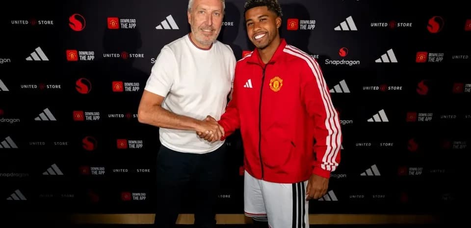 Two individuals shaking hands at Manchester United event