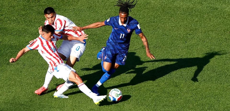 Paraguay and France players competing for the ball