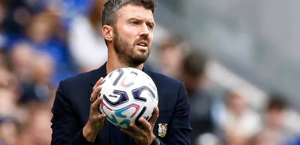 Coach holding a soccer ball during match