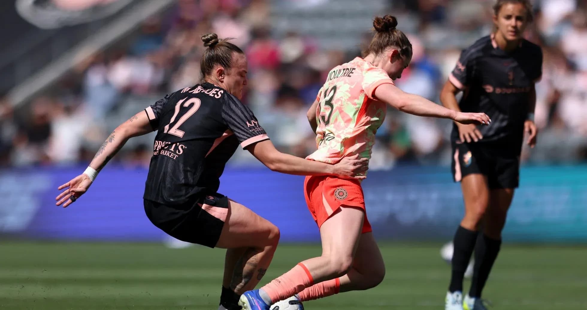 Player tackling opponent during NWSL match