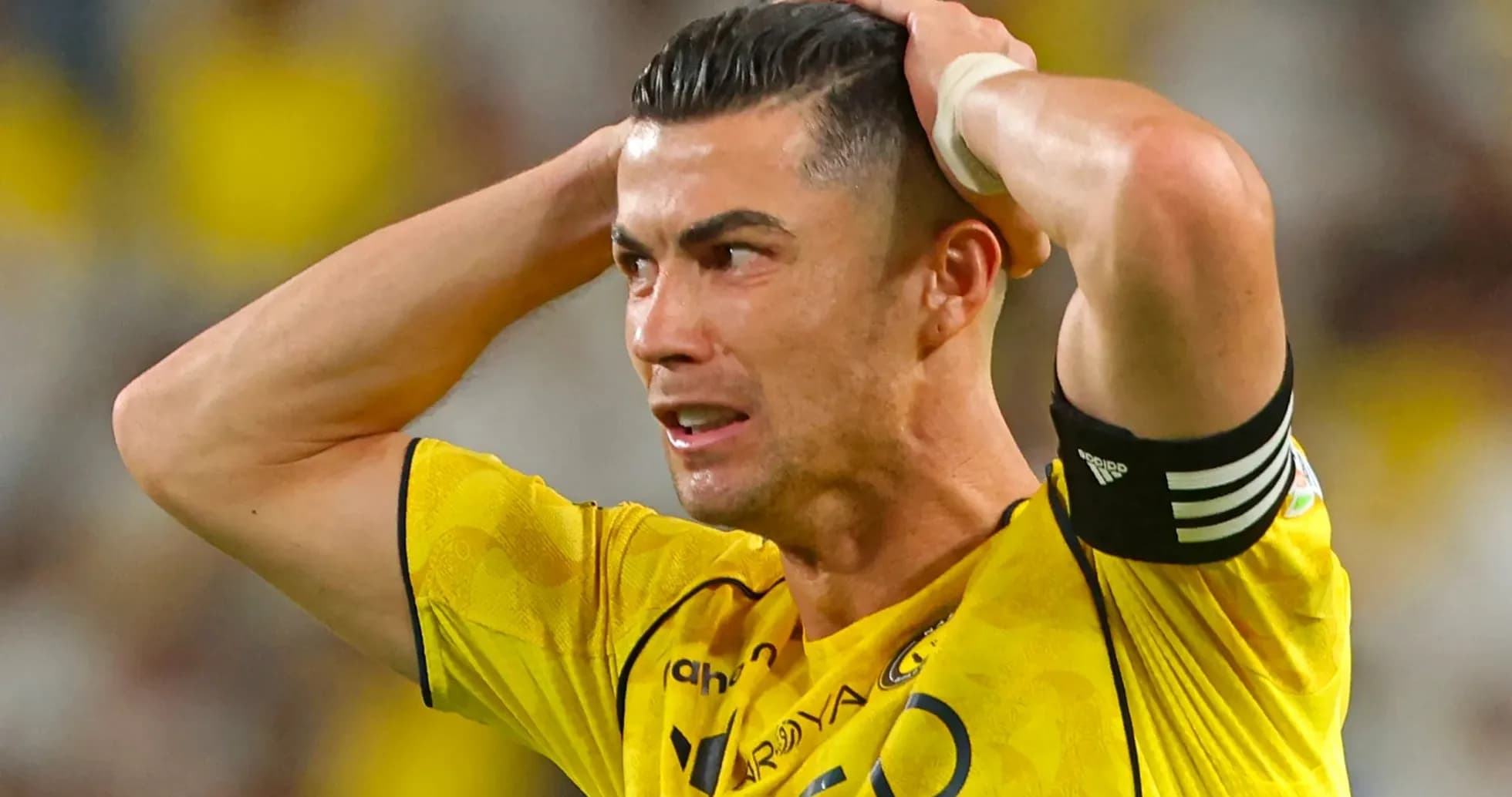 Player with hands on head in yellow jersey