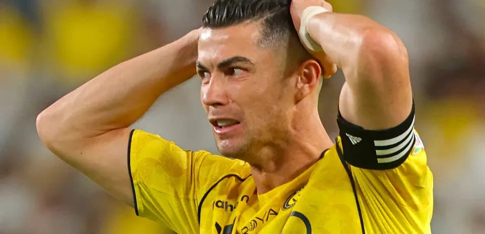 Player with hands on head in yellow jersey