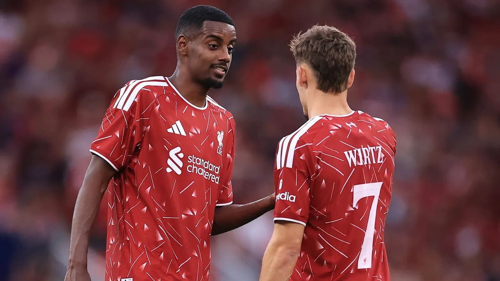 Two Liverpool players discussing on the pitch