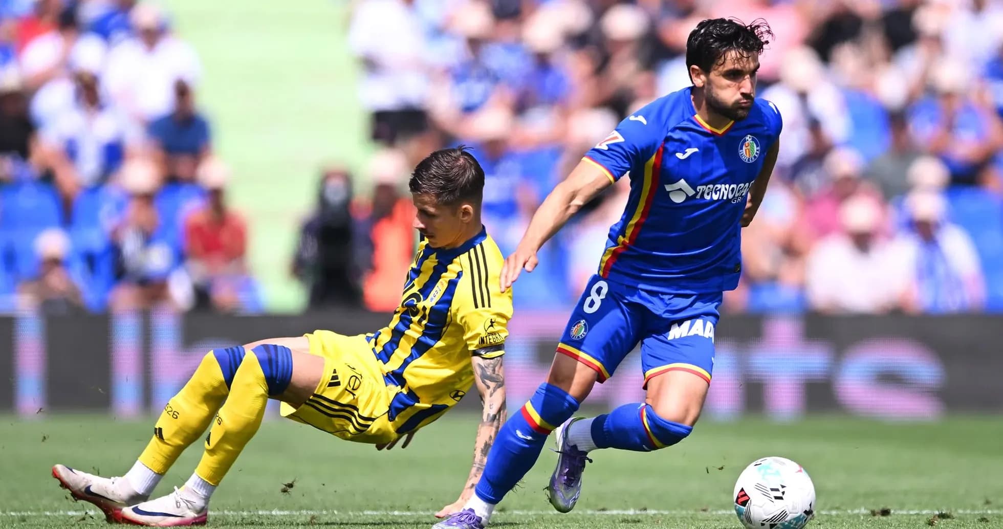 Oviedo player tackling Getafe opponent during match