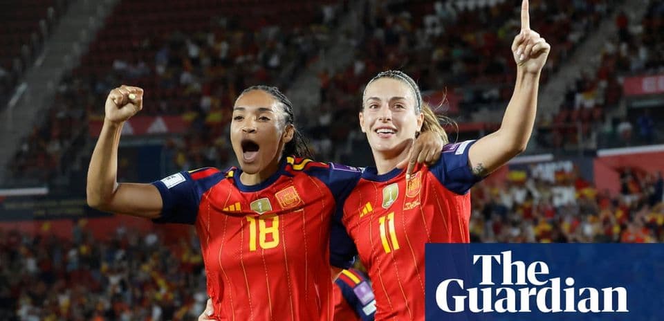 Two Spanish players celebrating a goal on field