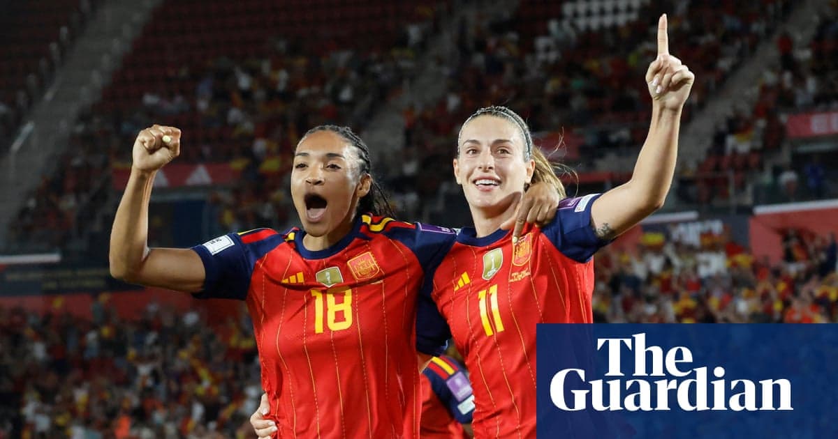 Two Spanish players celebrating a goal on field