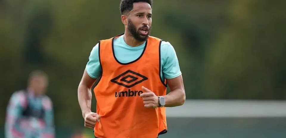 Player in orange training bib running on pitch