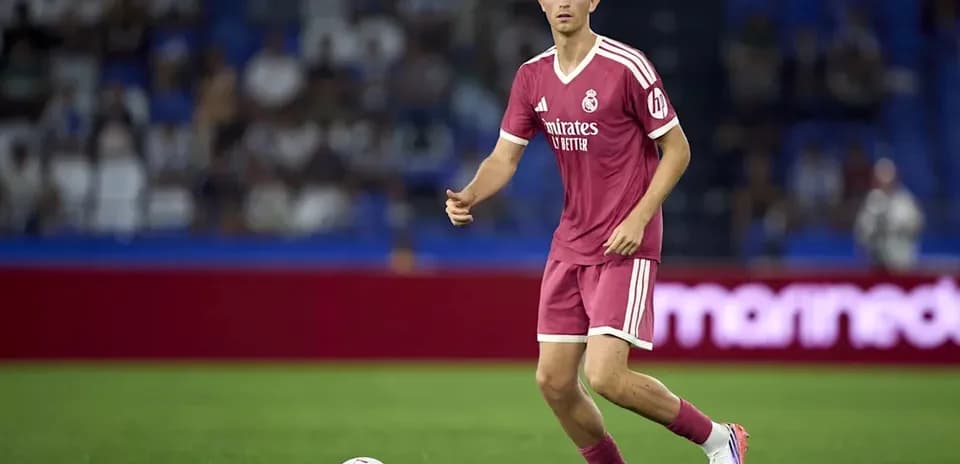 Player in pink kit preparing to pass ball
