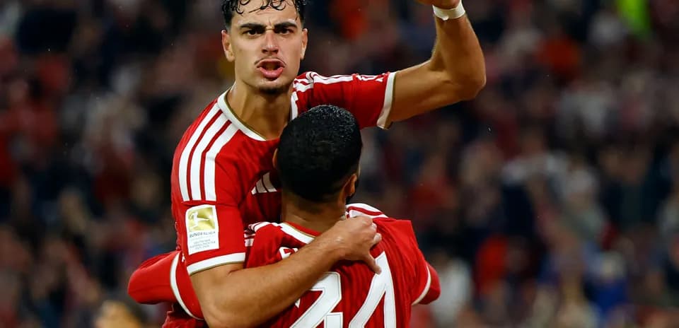 Two players celebrating a goal in red uniforms