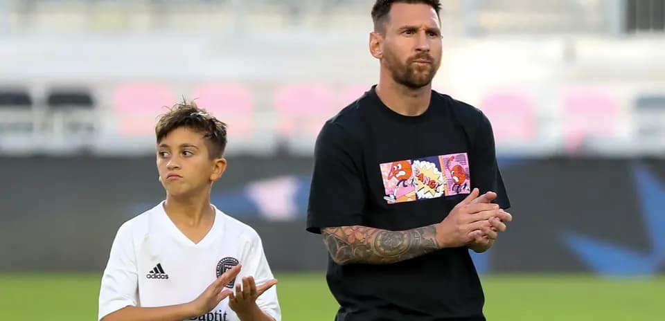 Lionel Messi and child applauding on the field