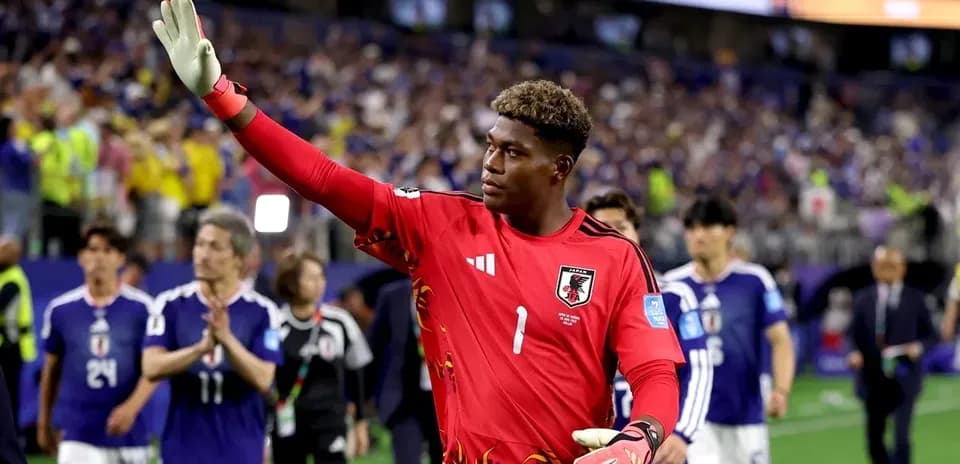 Goalkeeper in red jersey waving to the crowd