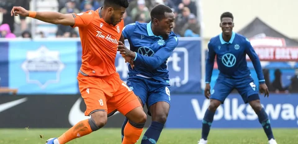 Cavalry FC player battling HFX Wanderers FC opponent