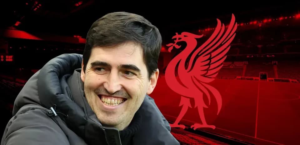 Smiling coach with Liverpool logo in background