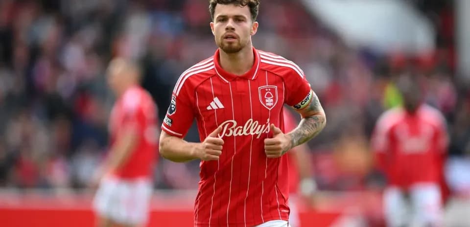 Player in red jersey jogging on the pitch